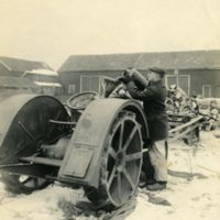 Leon A. Rushmore, Sr., loading fuel into a tractor to be used for sawing wood. c. winter 1918.jpg